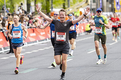 GENERALI BERLIN HALF MARATHON: A happy runner throws his hands up shortly before the finish of the GENERALI BERLIN HALF MARATHON 2024.© SCC EVENTS // Jean-Marc Wiesner