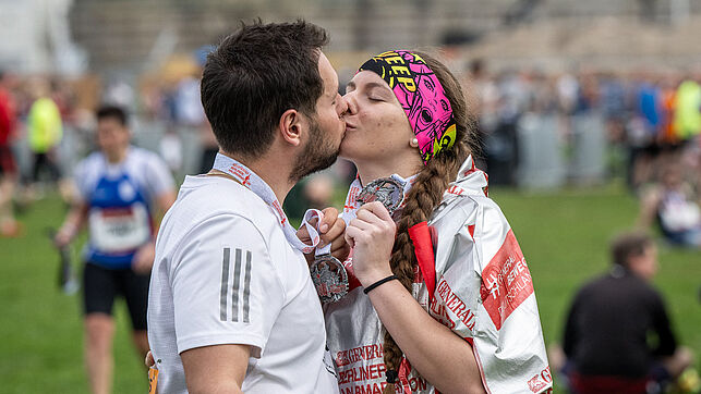  A couple kissing with the medal around their necks 