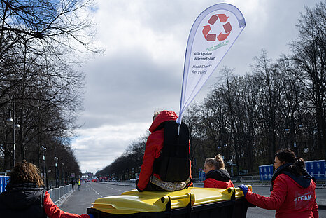 GENERALI BERLIN HALF MARATHON: Team members push a barrel of returned thermal foil along the Straße des 17. Juni © SCC EVENTS / Annegret Hilse