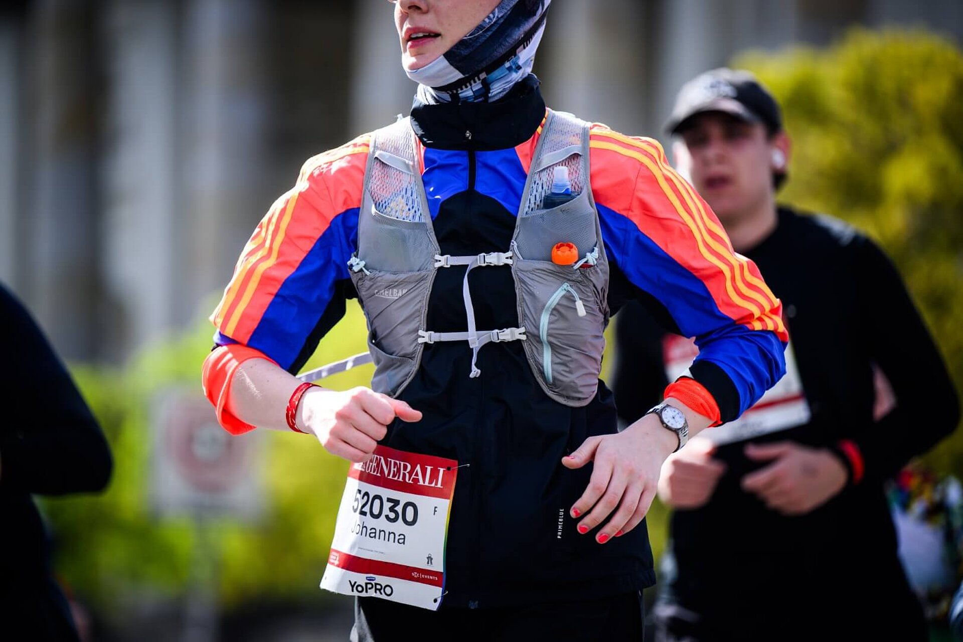 Läuferin mit Trinkweste, aus der ein Gelpäckchen rausschaut.