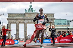 Sebastian Sawe läuft durchs Ziel des GENERALI BERLINER HALBMARATHON, im Hintergrund das Brandenburger Tor