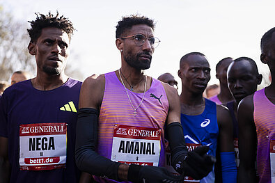 Zentral: Top-Athlet Amanal Petros, links daneben Nega Bereket stehen bereit und fokussiert an der Startlinie.