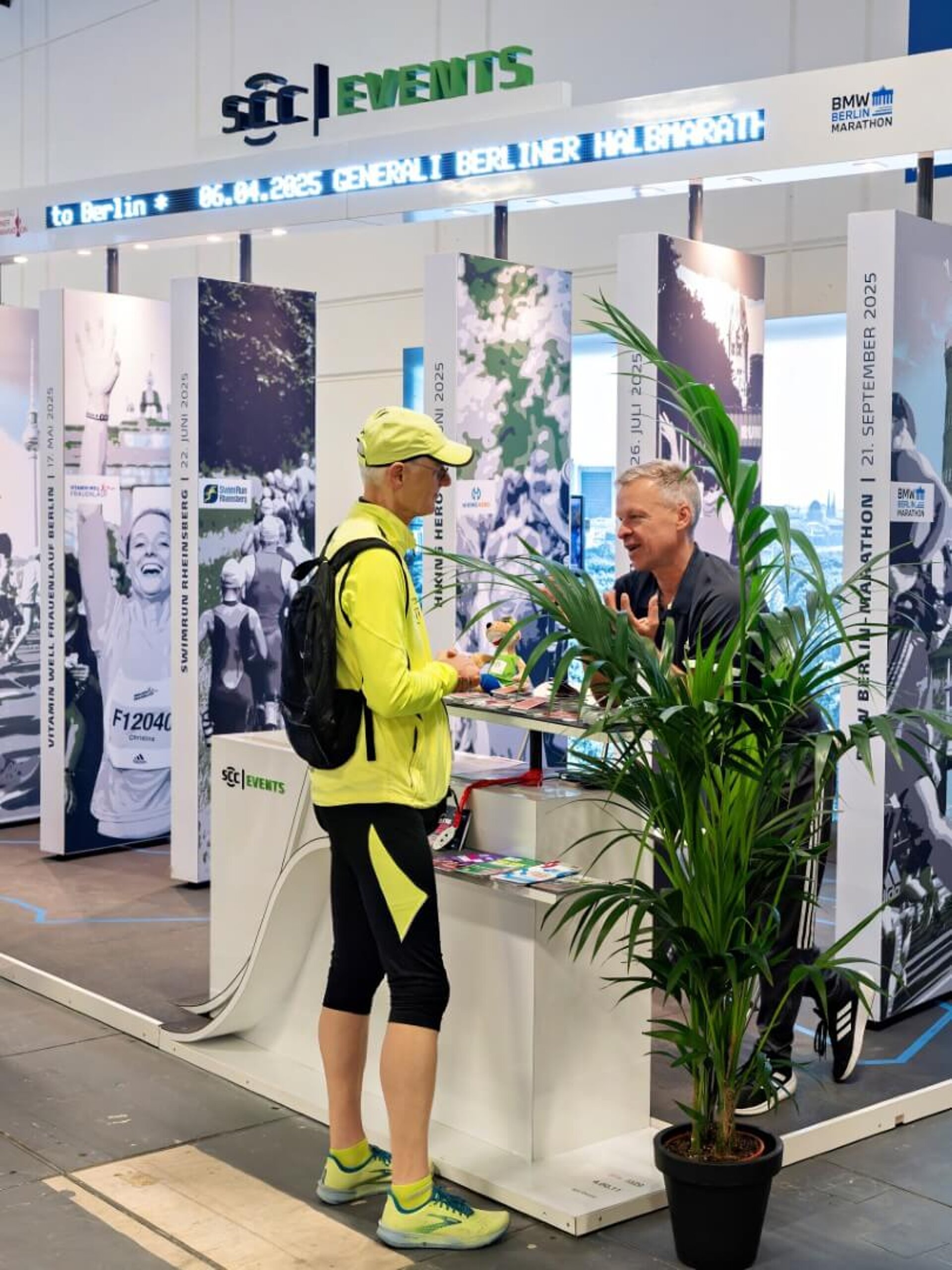 Teilnehmer unterhält sich mit Mitarbeiter am SCC EVENTS Stand.