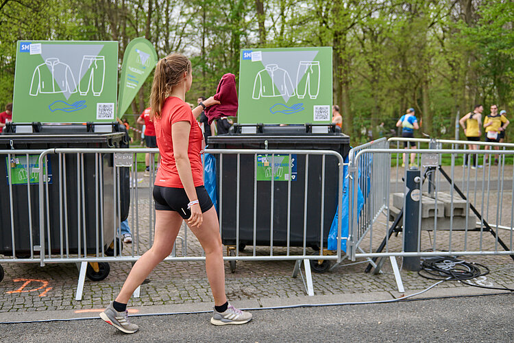 GENERALI BERLINER HALBMARATHON: Kleiderspende einer Läuferin auf der Strecke © SCC EVENTS