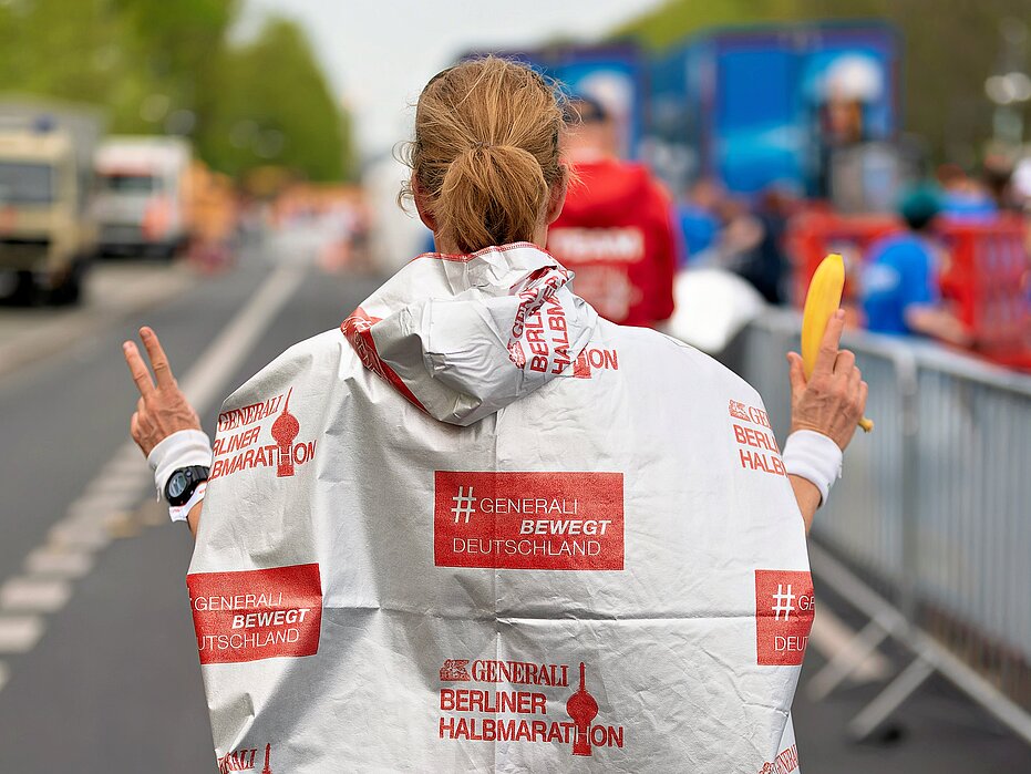 GENERALI BERLIN HALF MARATHON: Participant with poncho after the race © SCC EVENTS / Christian Lietzmann