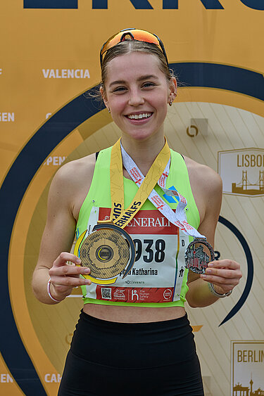 A beaming runner with a SuperHalf medal.