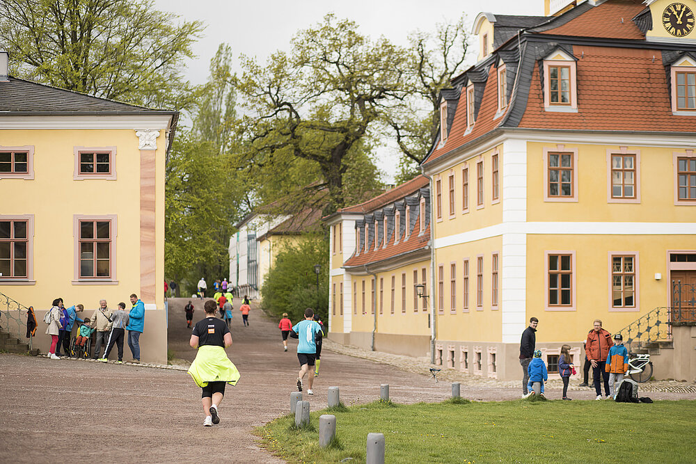 Läufer:innen umringt von historischen Gebäuden.