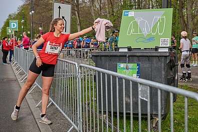 GENERALI BERLINER HALBMARATHON: Kleiderspende einer Läuferin auf der Strecke © SCC EVENTS