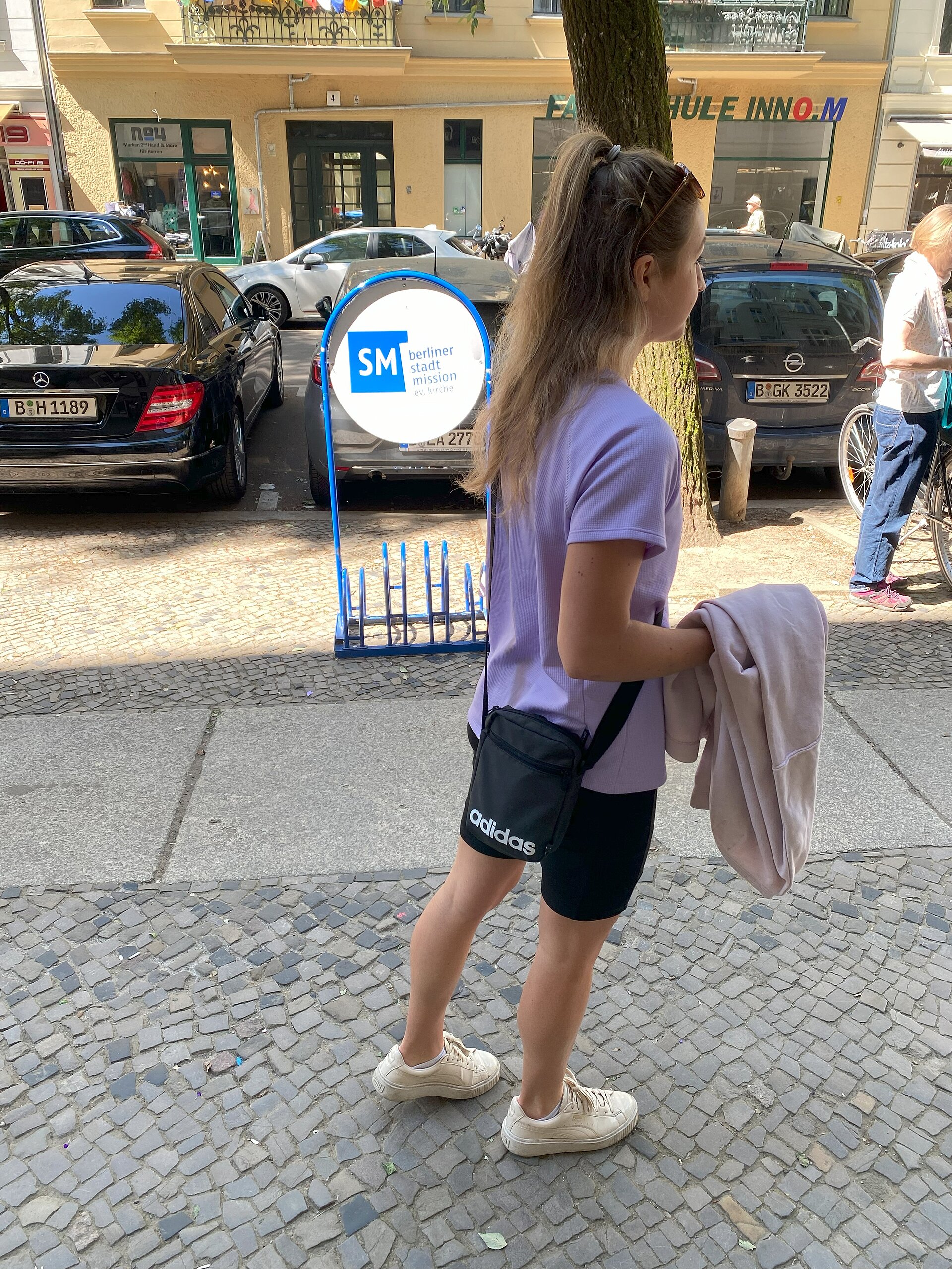 Junge Frau mit Kleiderspende in der Hand.