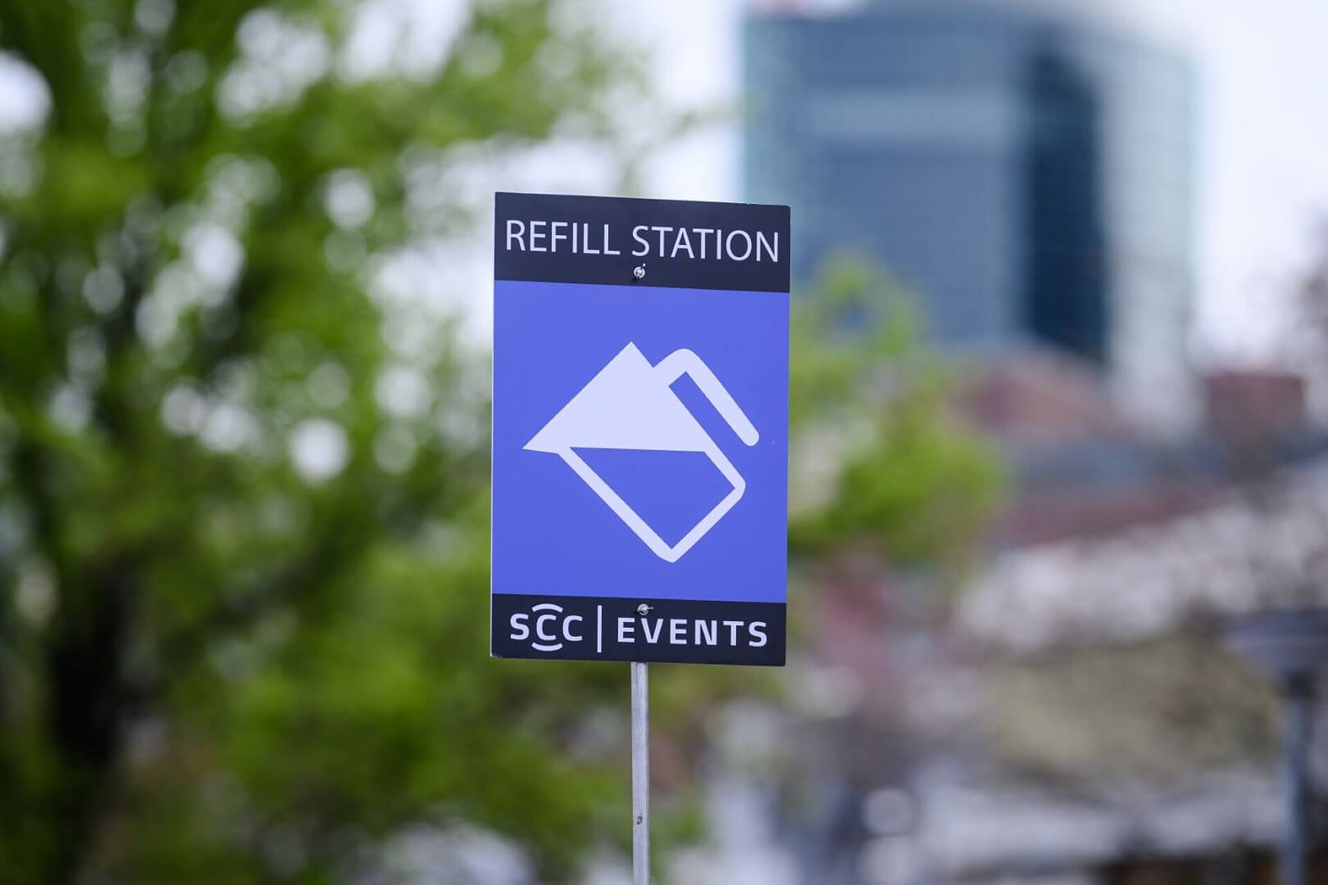 A blue sign from SCC EVENTS with the words “Refill Station” and a symbolic white water carafe.