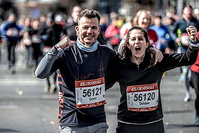GENERALI BERLIN HALF MARATHON 2022: A pair of runners raise their fists arm in arm and rejoice © SCC EVENTS
