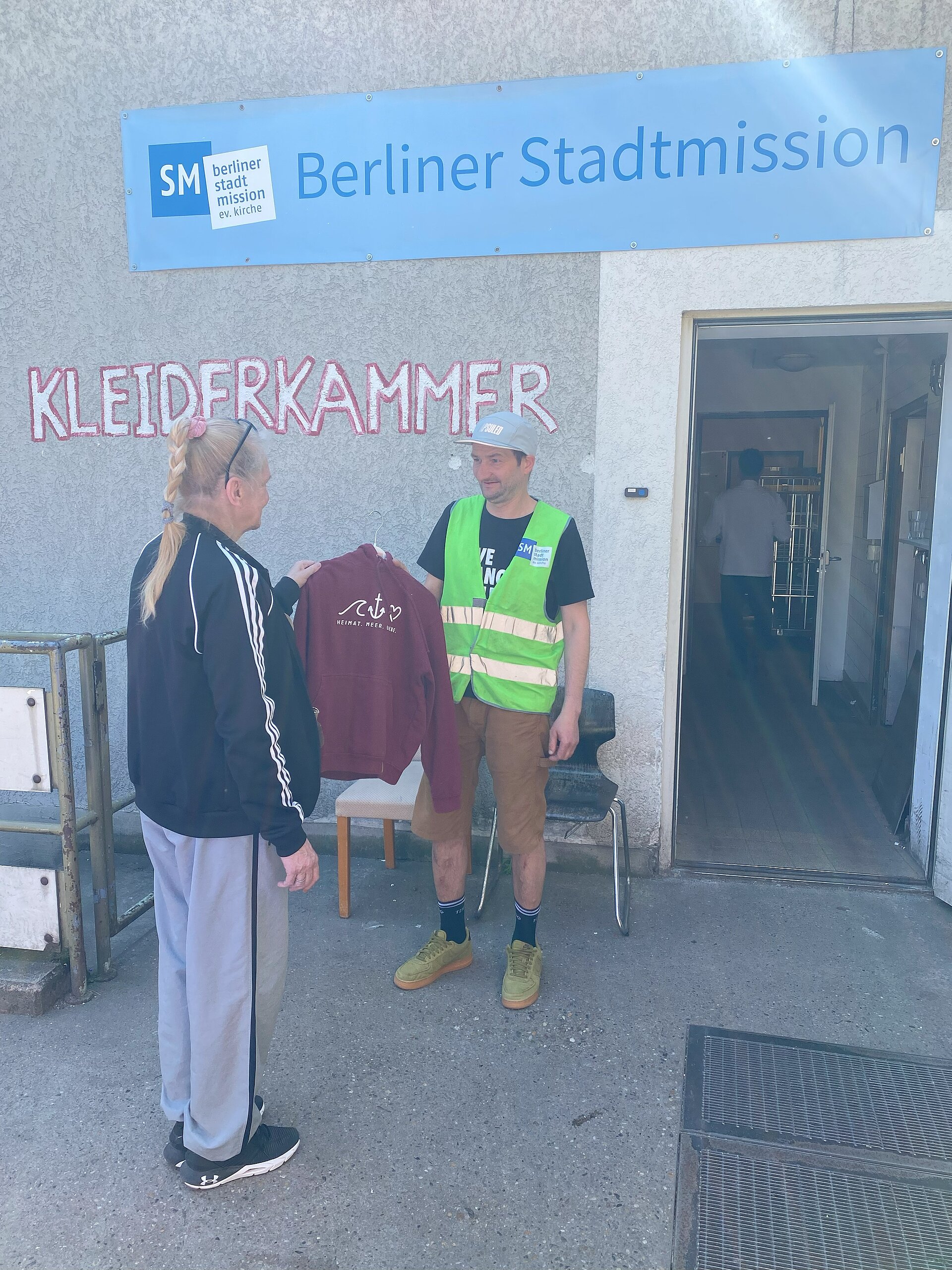 Kleidungsübergabe vor der Berliner Stadtmission.