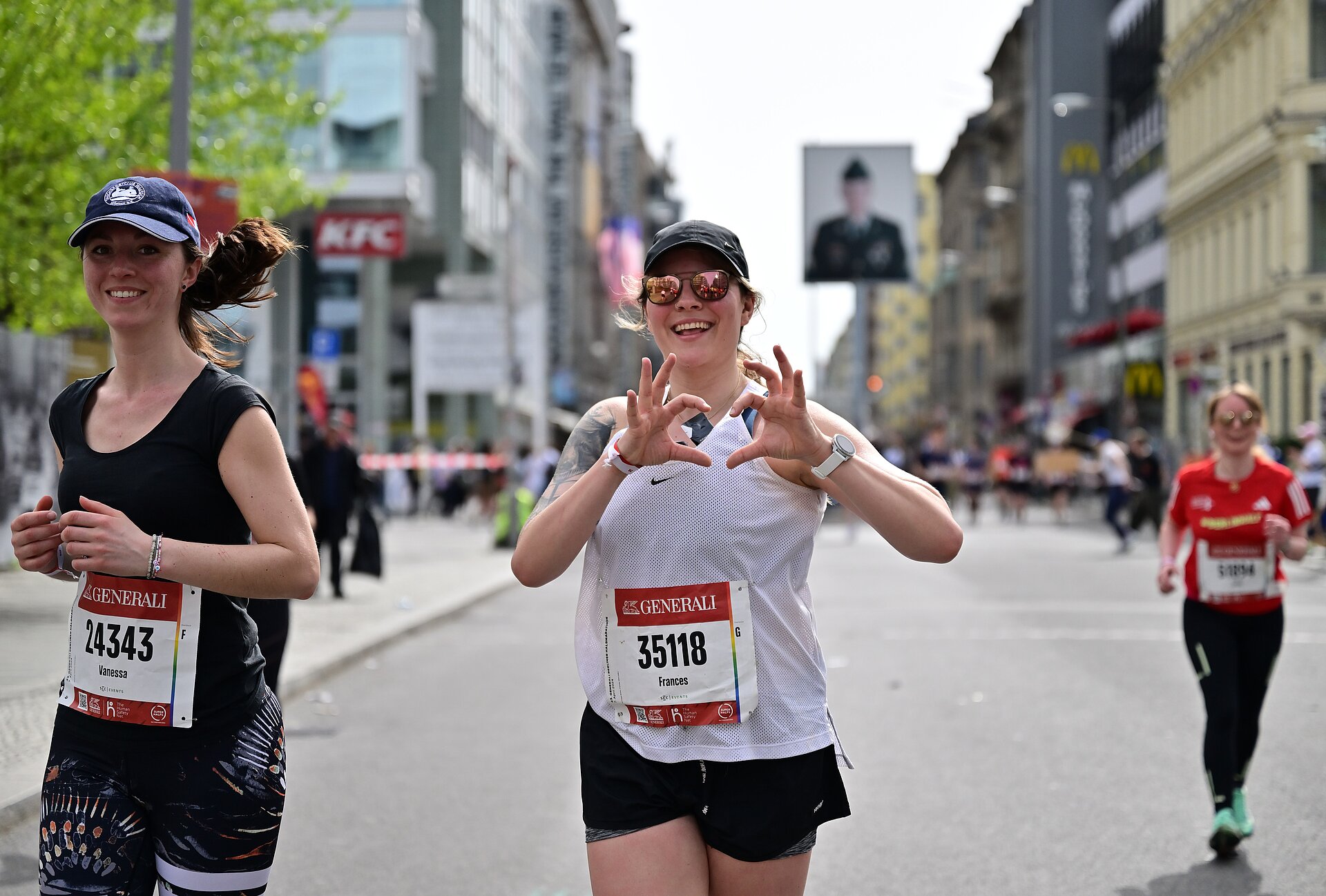 GENERALI BERLIN HALF MARATHON: female runner forms a heart with her hands and holds it up to the camera © Petko Beier/ SCC EVENTS