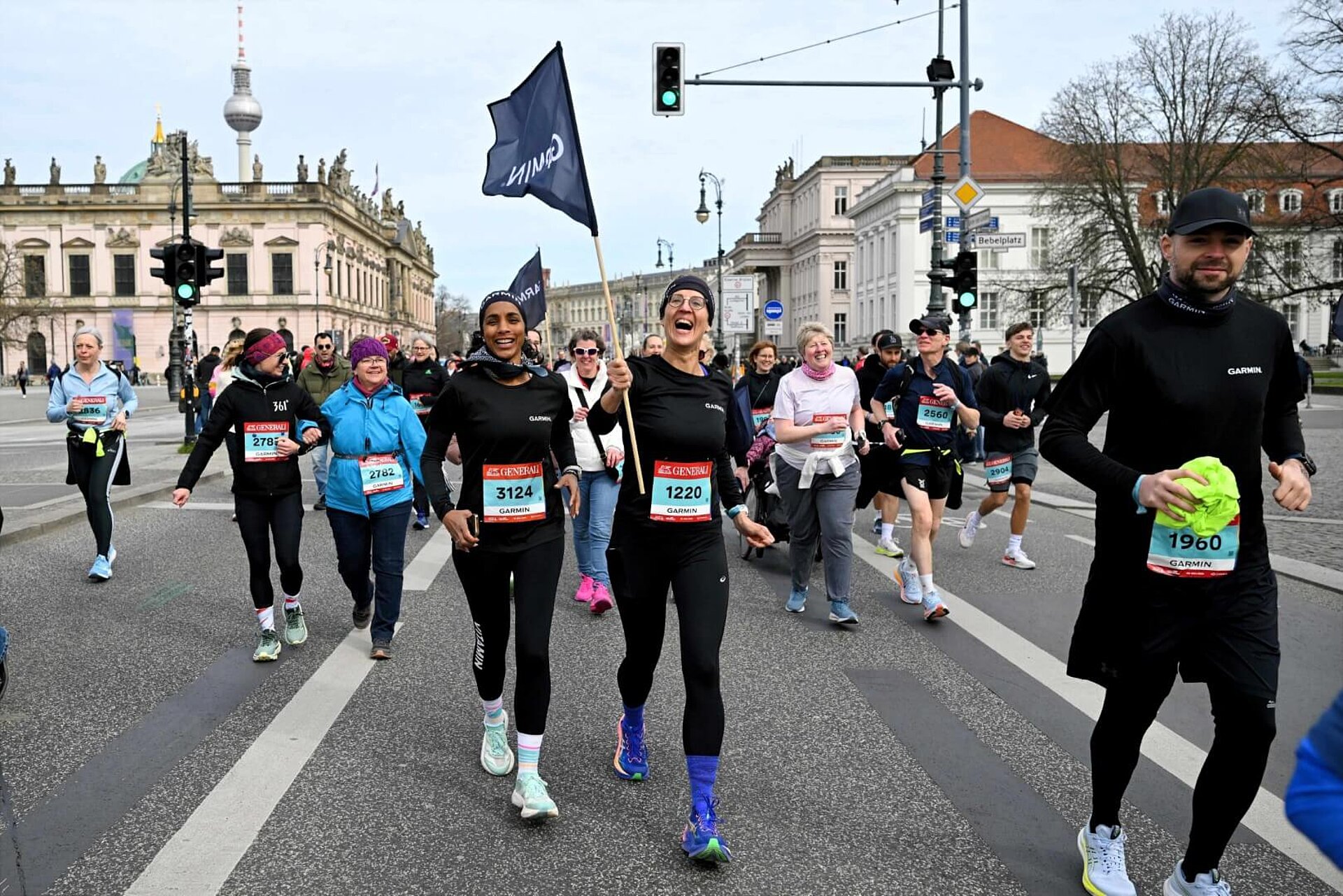 Glückliche Läuferinnen schwenken eine Fahne auf der Strecke.