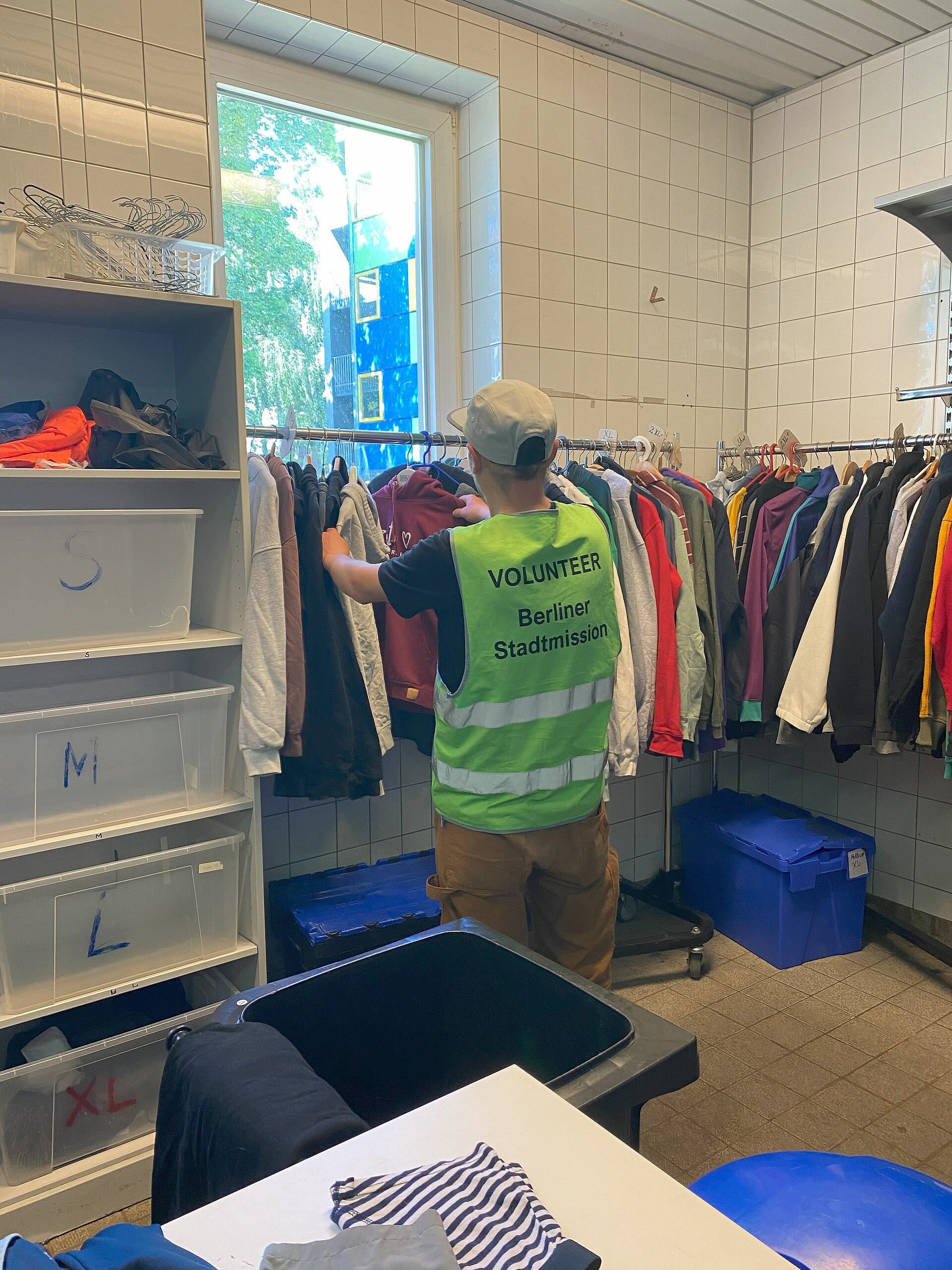 Ein Volunteer der Berliner Stadtmission in der Kleiderkammer.