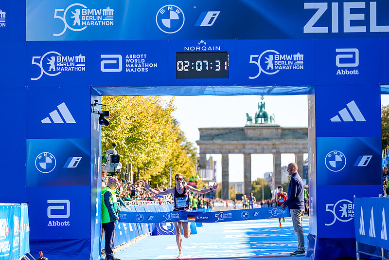 Erster Deutscher Läufer Sebastian Hendel läuft durchs Zieltor des 50. BMW BERLIN-MARATHON. Die Uhr zeigt 02:07:32 an.